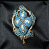 Broche Art Nouveau (ppos. s. XX) con detalles en diamantes, esmaltado al fuego color turquesa y motivos calados, realizado en oro amarillo de ley 18 kts.  *Nota: Tiene un broche a juego que se vende por separado.