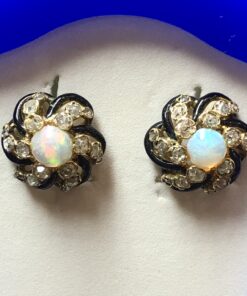 Bonitos pendientes de finales del s. XIX en forma de rosetones con ópalos blancos y 0'50 cts de diamantes, realizados en oro amarillo de ley 18 kts con esmaltado negro.
