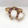Sortija vintage (años 40) en forma de herradura con diamantes y rubíes, realizada en oro amarillo de ley 18 kts.