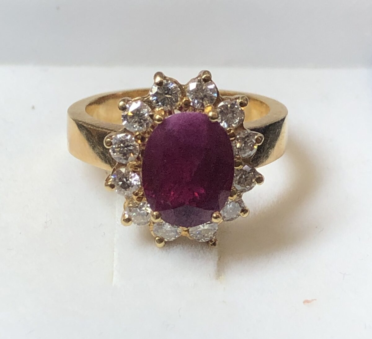 Sortija de rosetón con rubí de 2'30 cts y orla de brillantes de 0'60 cts, realizado en oro amarillo de ley 18 kts.