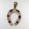 Colgante vintage en forma de herradura con 1'70 cts de brillantes y 0'75 cts de rubíes naturales, realizado en oro amarillo de ley 18 kts.