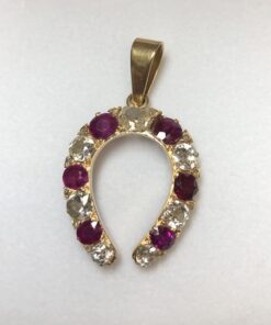 Colgante vintage en forma de herradura con 1'70 cts de brillantes y 0'75 cts de rubíes naturales, realizado en oro amarillo de ley 18 kts.