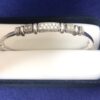 Pulsera rígida con diseño geométrico y 0'32 cts de brillantes, realizada en oro blanco de ley 18 kts.
