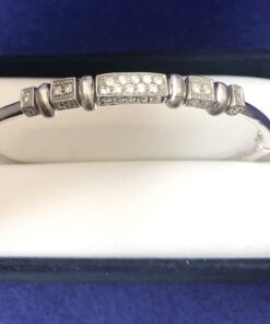 Pulsera rígida con diseño geométrico y 0'32 cts de brillantes, realizada en oro blanco de ley 18 kts.