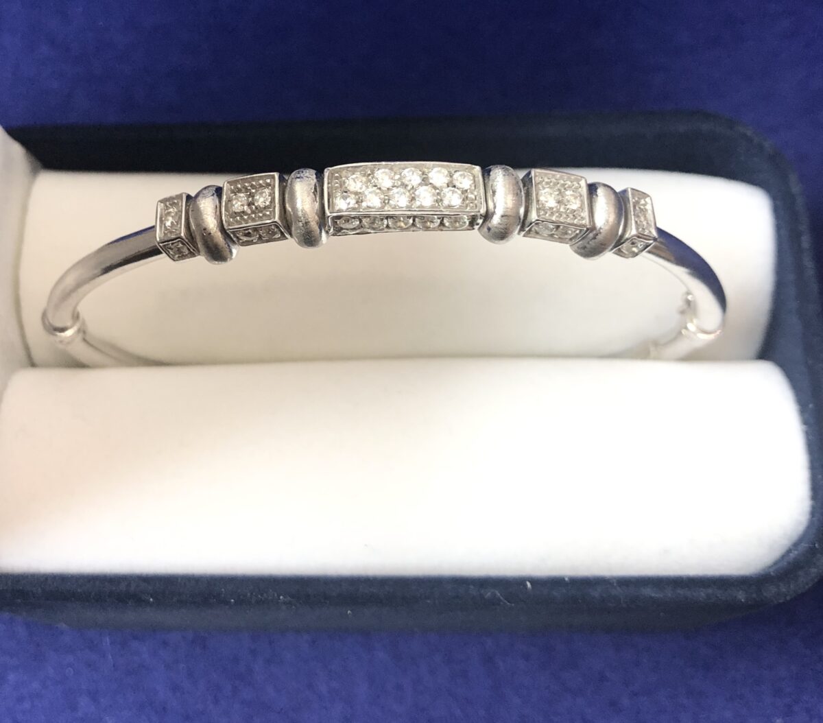 Pulsera rígida con diseño geométrico y 0'32 cts de brillantes, realizada en oro blanco de ley 18 kts.