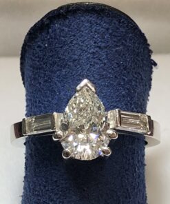 Sortija de pedida con diamante central talla pera de 1'40 cts, color J-SI y diamantes laterales en baguette de 0'10 cts cada uno, color H-VS1.