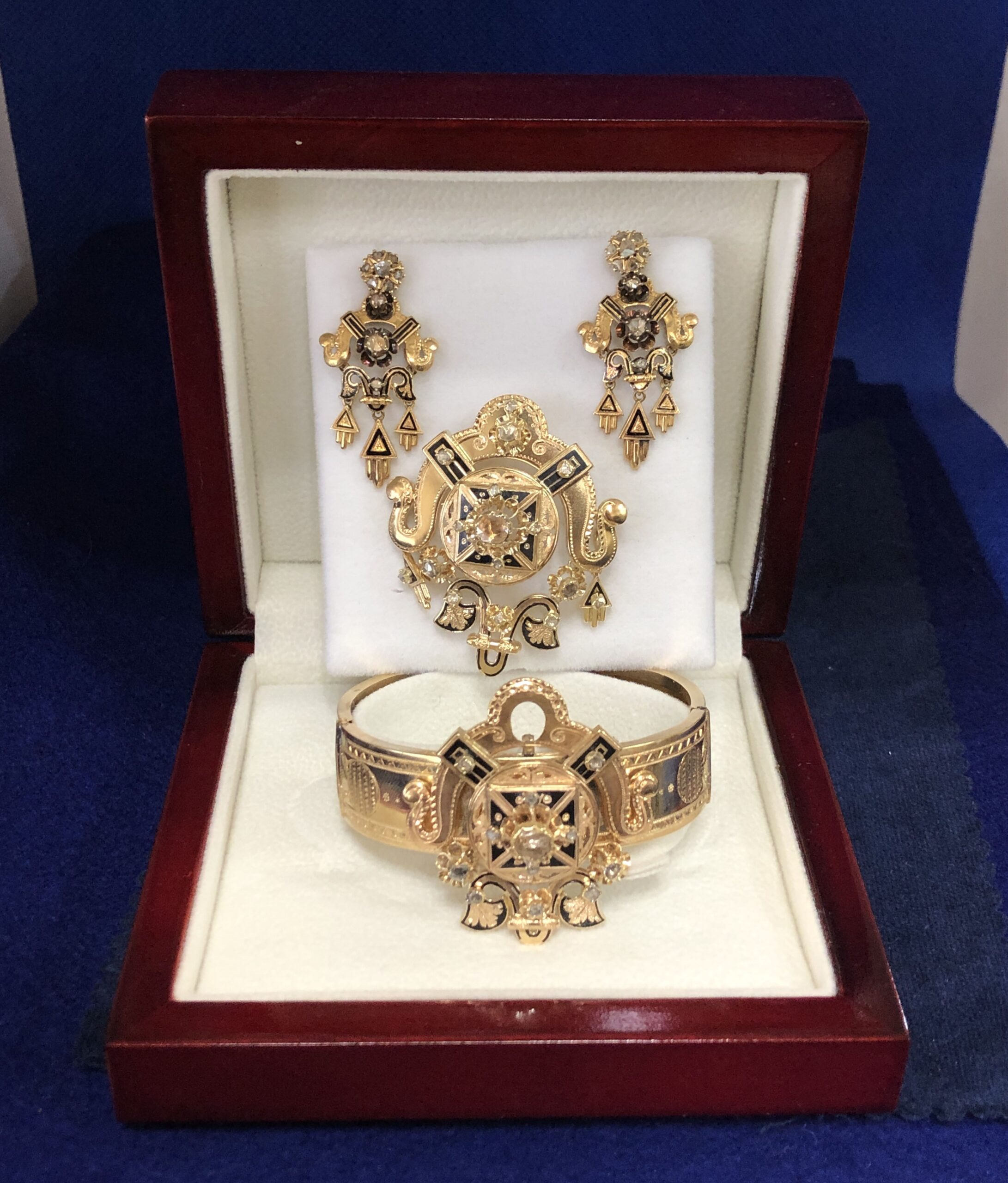 Aderezo Isabelino (finales del s. XIX) compuesto por pulsera, pendientes y broche, realizado en oro amarillo de ley 18 kts con esmaltado negro y diamantes talla antigua.